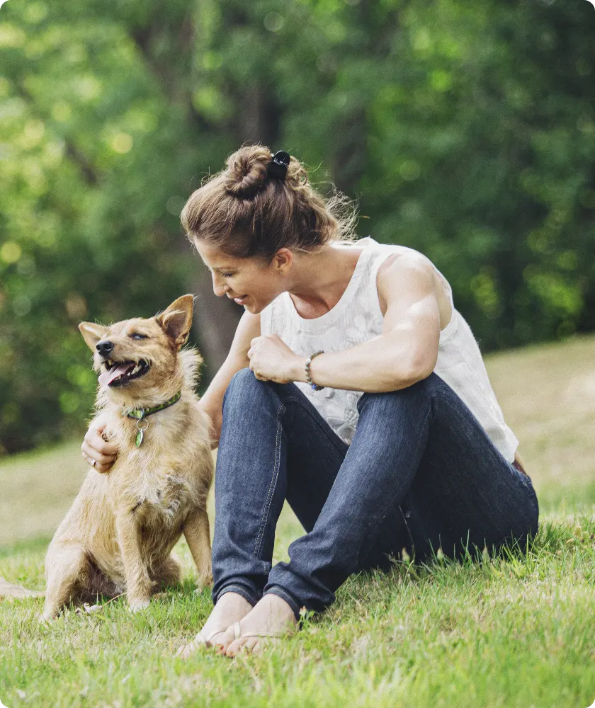 Woman petting dog in a field