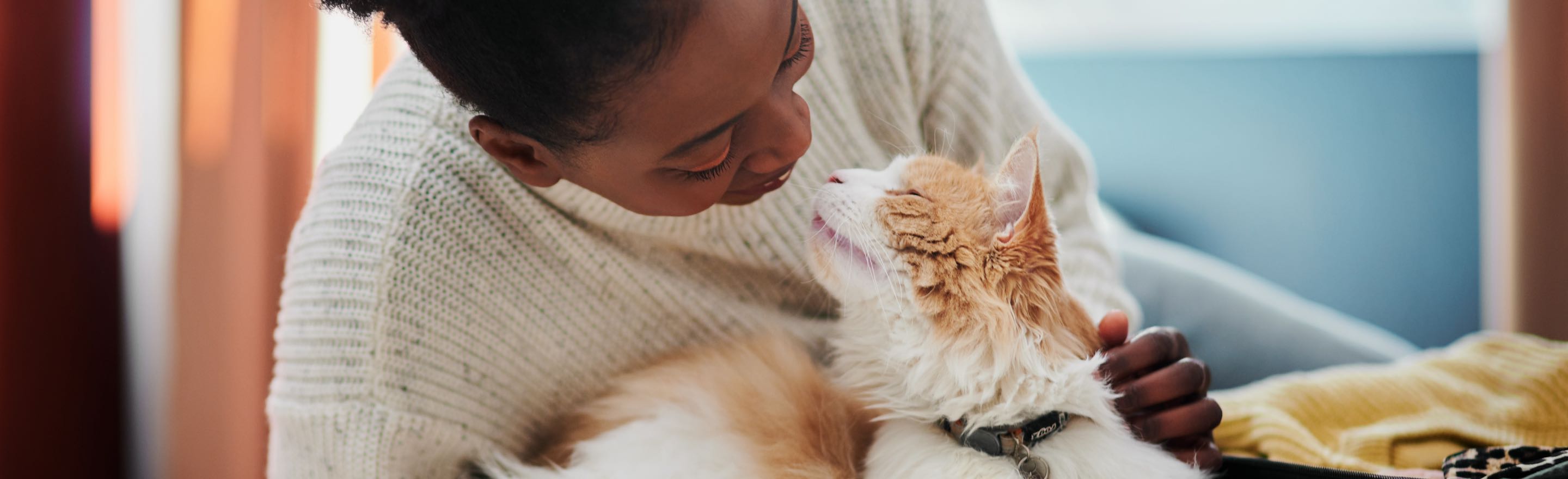 A woman holding a cat in her arms.