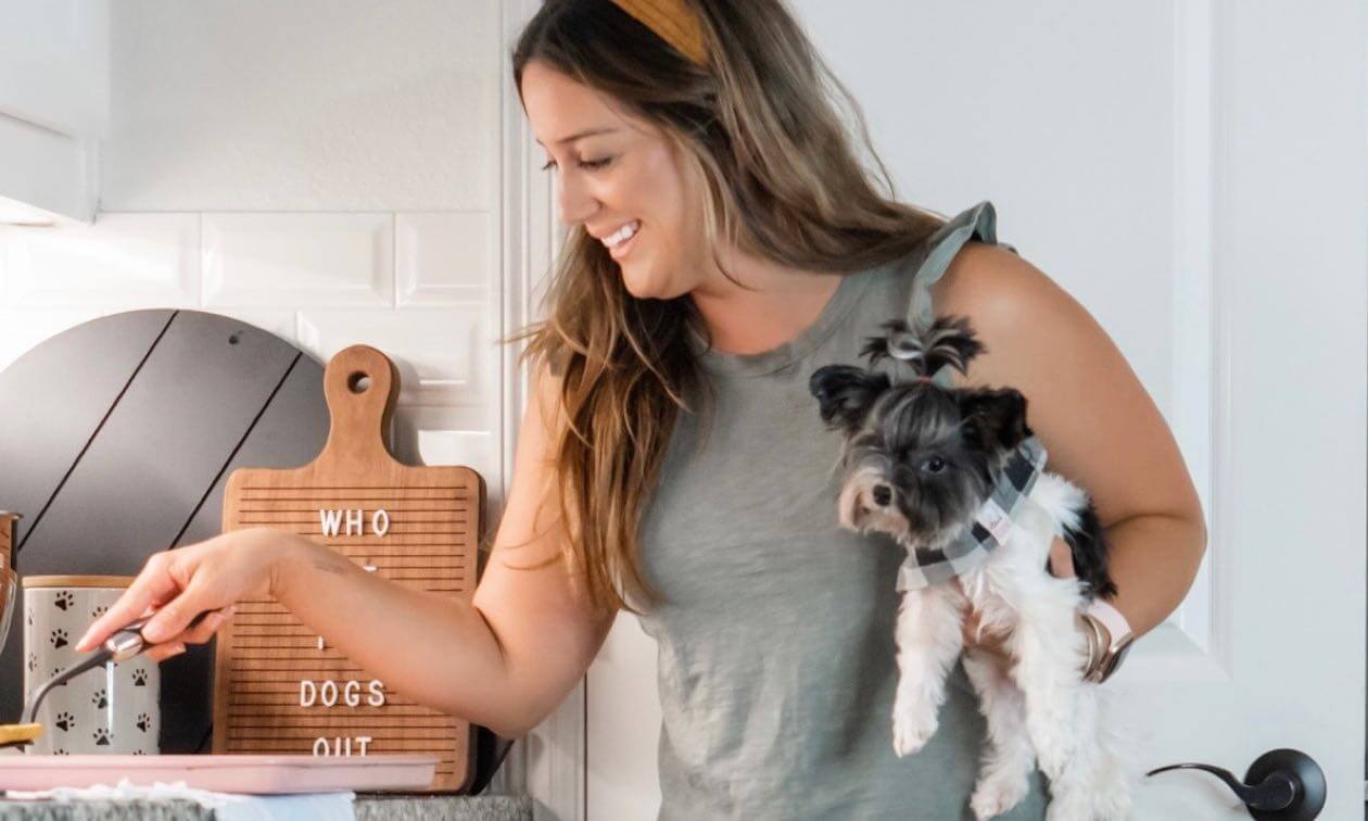 A woman holding a small dog in her arms.