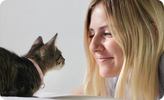 Lady smiling to her cat.