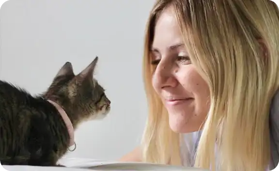 Lady smiling to her cat.