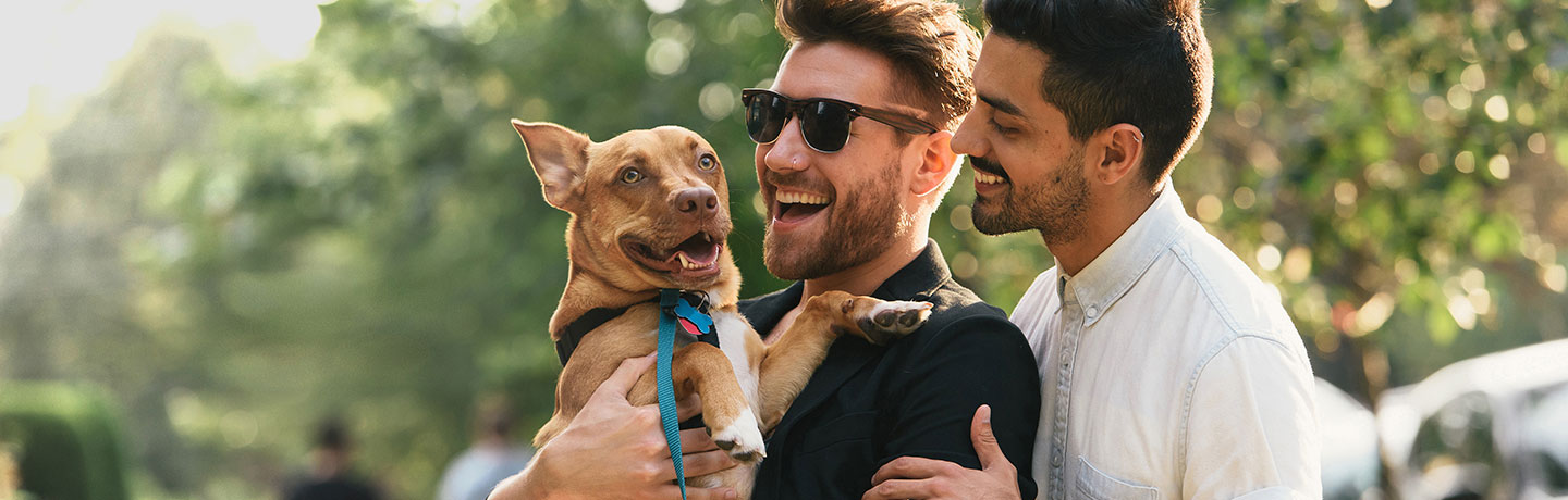 two men holding their dog