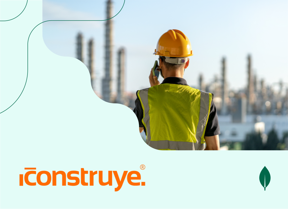 A construction worker standing on top of a building, talking on a phone.