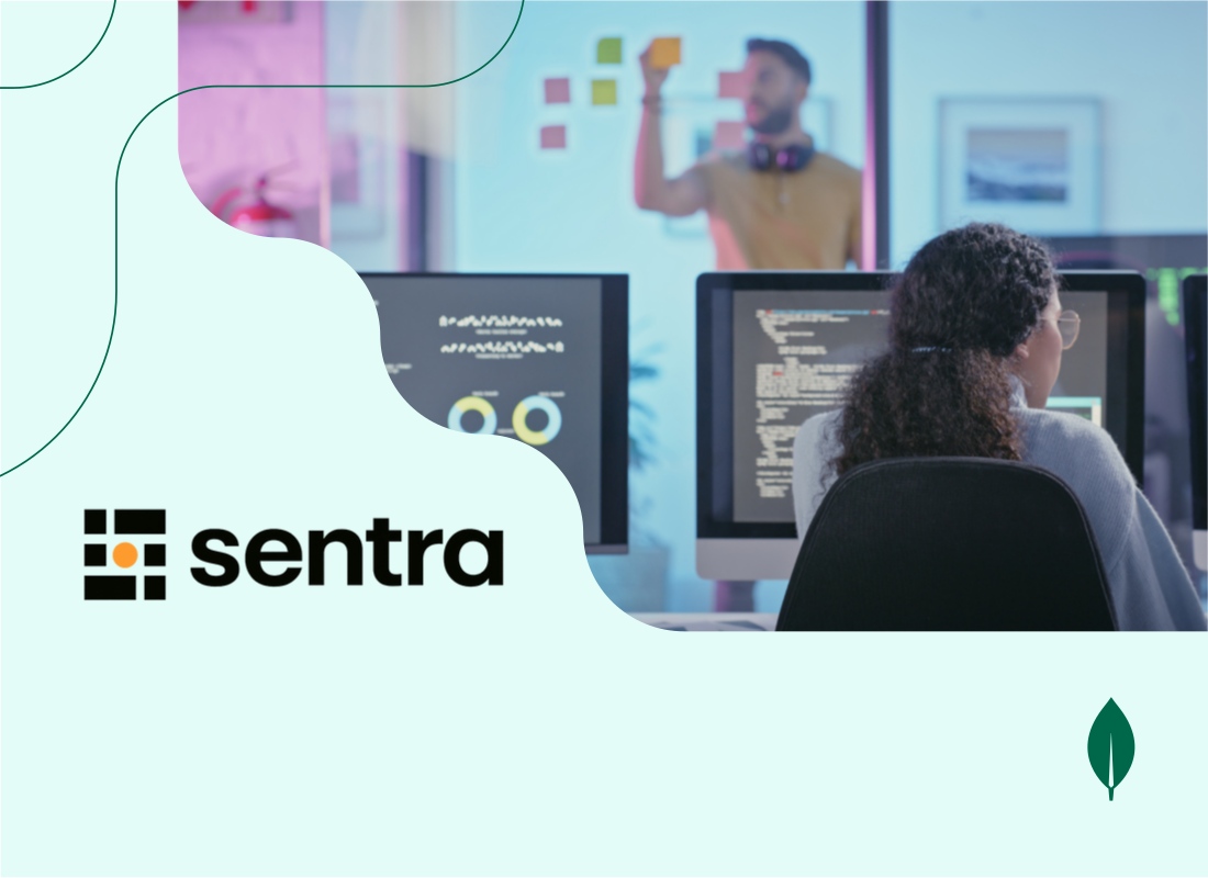 A young woman focused on her work at a Mac computer in an office environment.