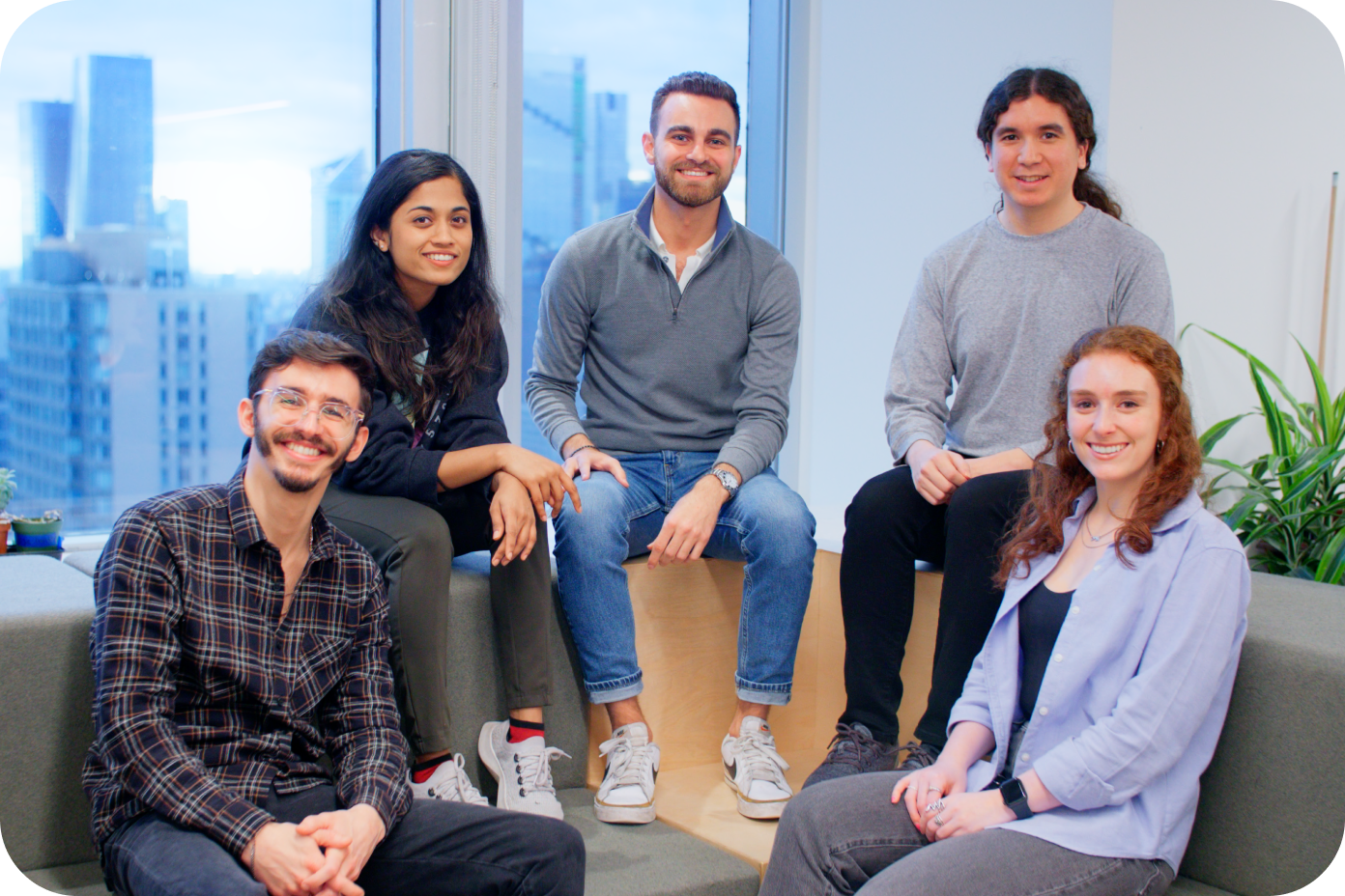 Grupo de empleados de MongoDB sonriendo en la oficina
