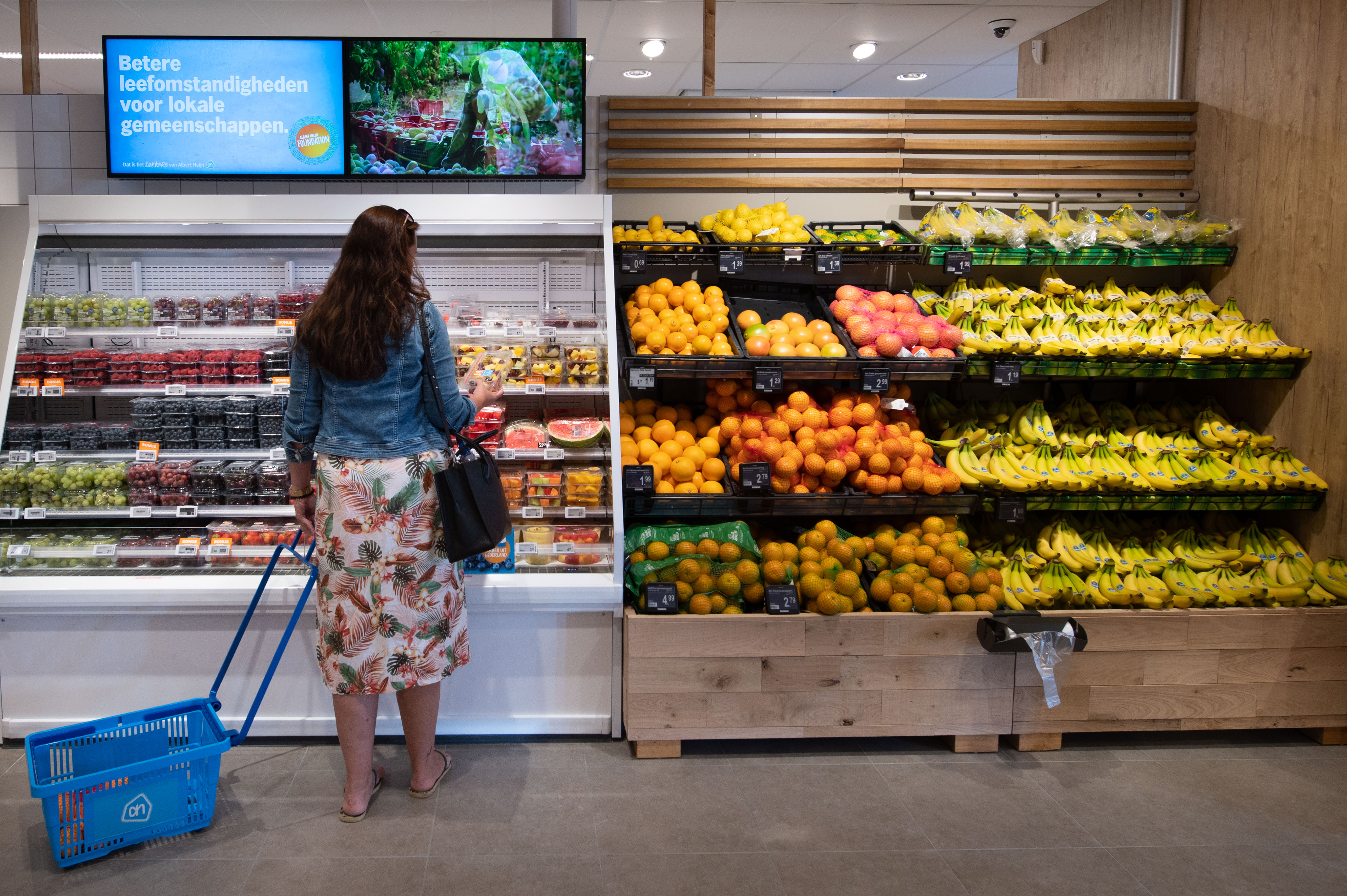 An illustration of a woman choosing fruits in a supermarket