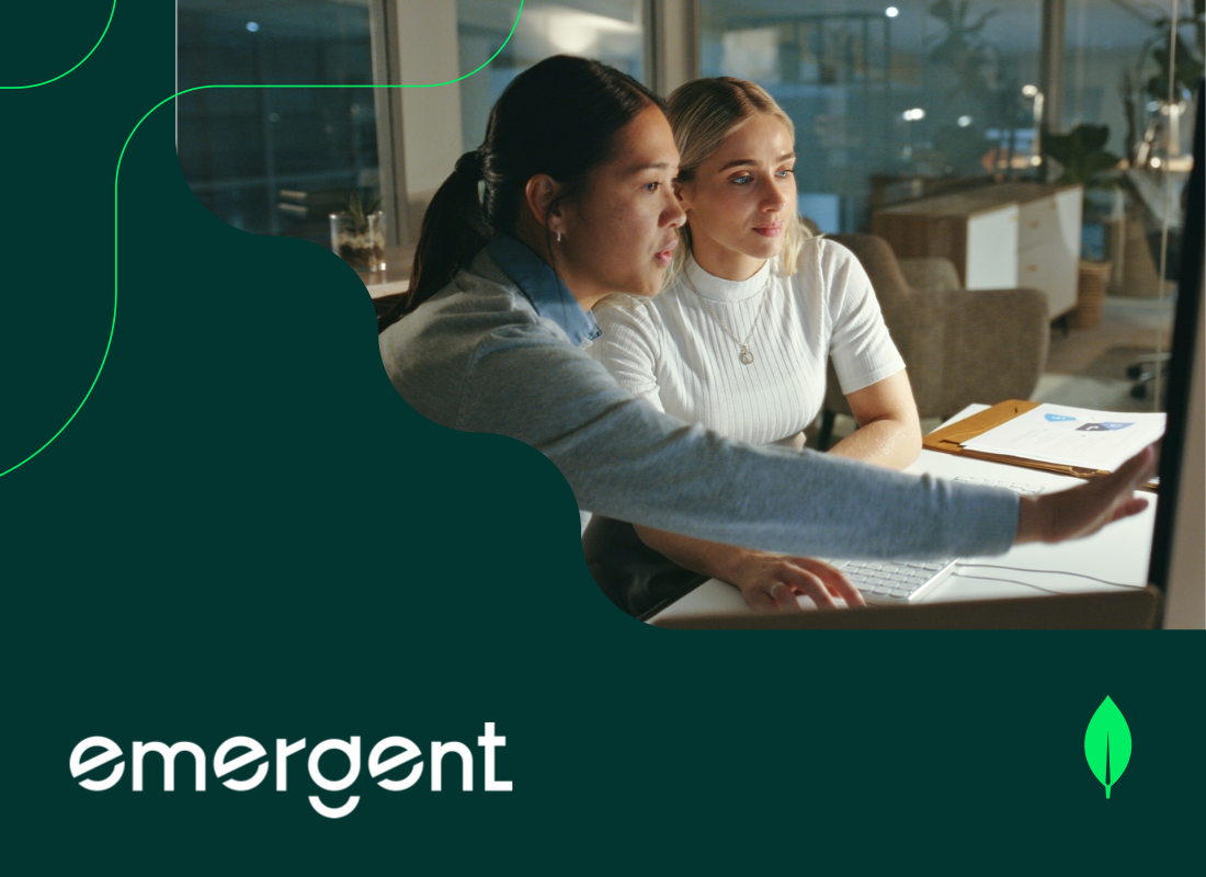 Two young women are looking at a computer monitor and discussing something.