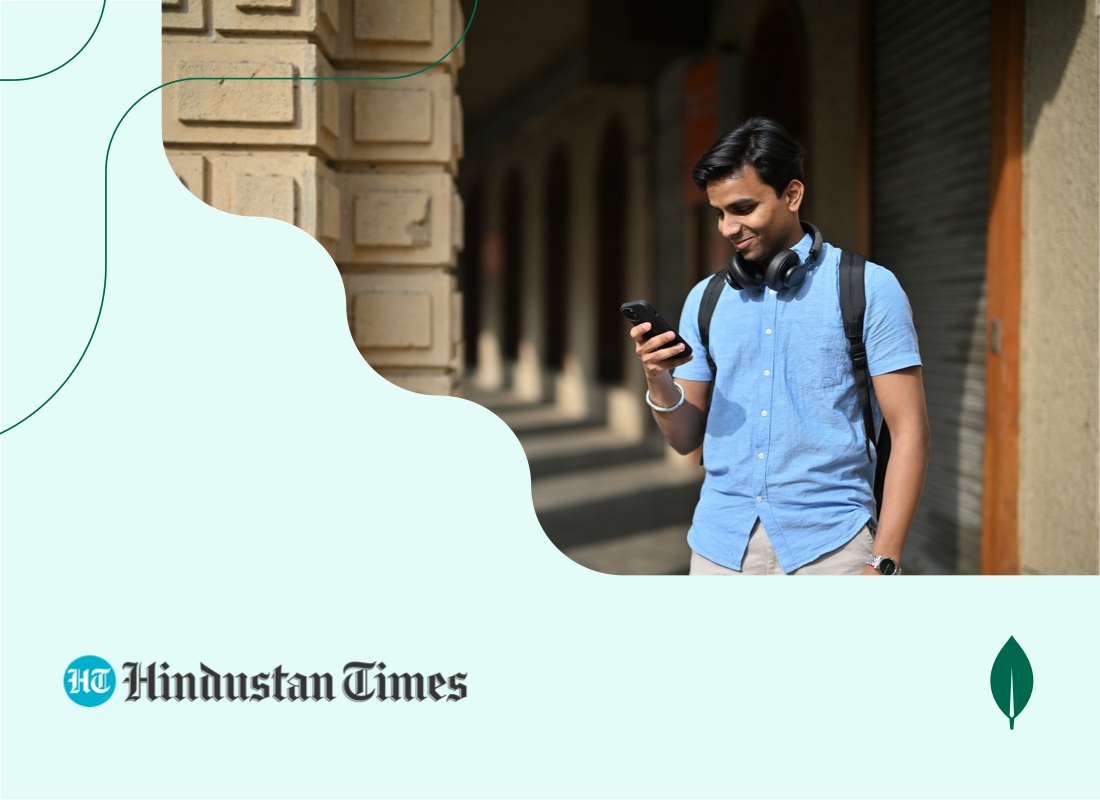 A young person holding and looking at a mobile phone.