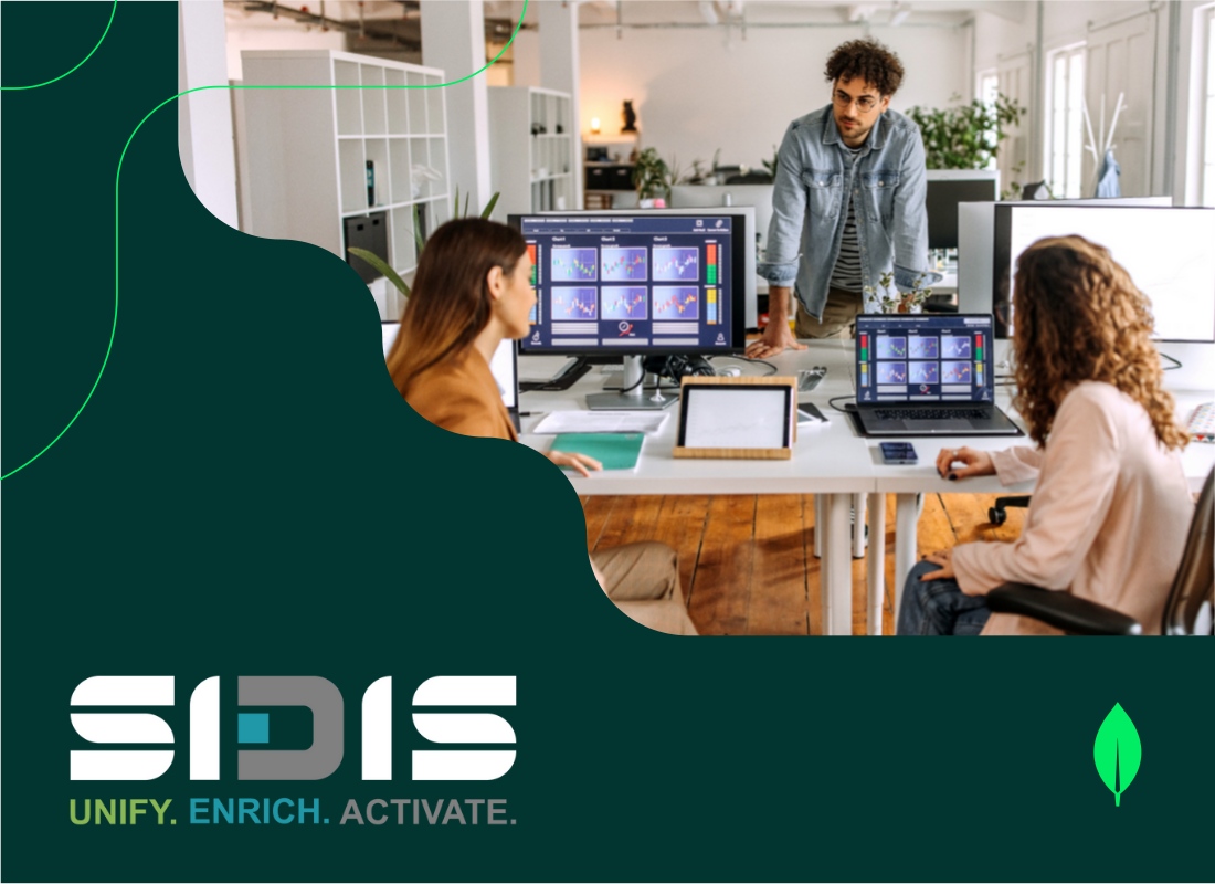 A group of professionals discussing data management in front of a desktop.