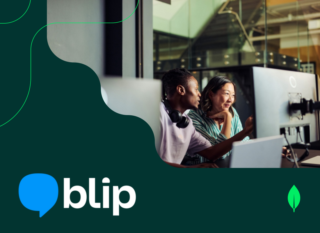 Two young professionals sitting in an office, collaborating while viewing a monitor.