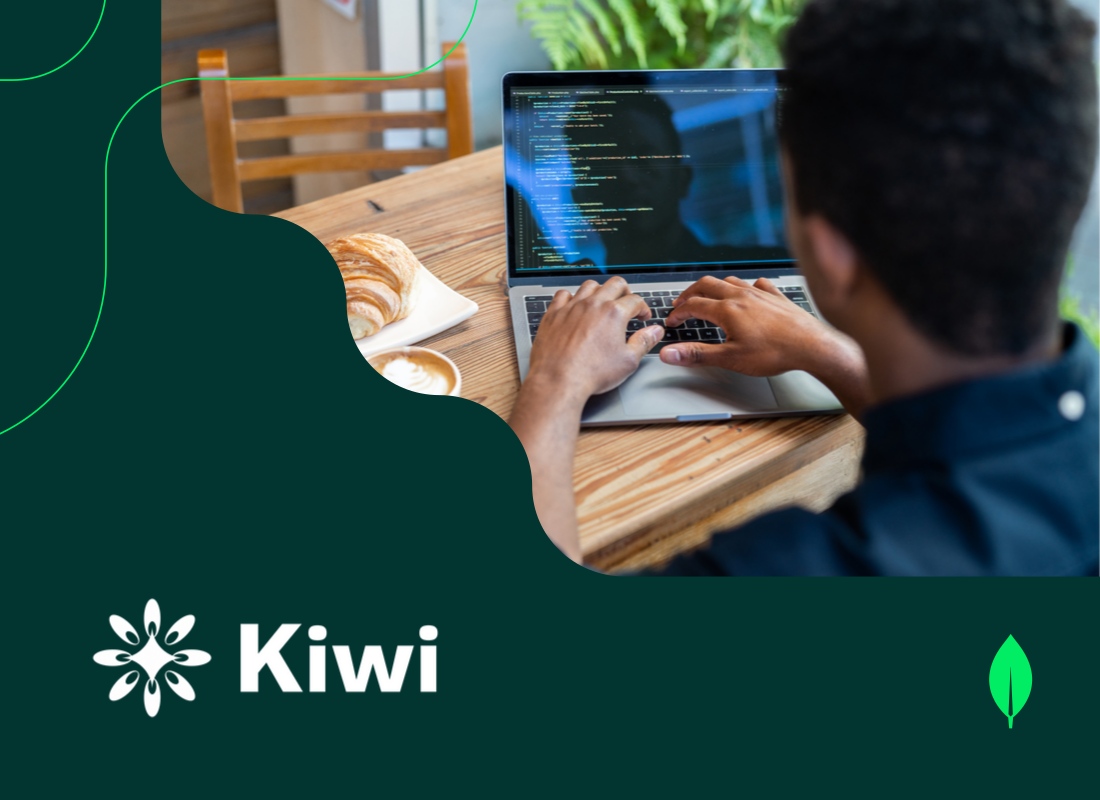 A professional sitting at a desk, working on a laptop with coding displayed on the screen.