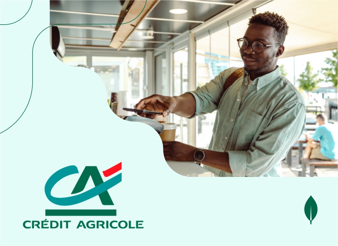 A man using his smartphone to make a digital payment at a coffee shop.