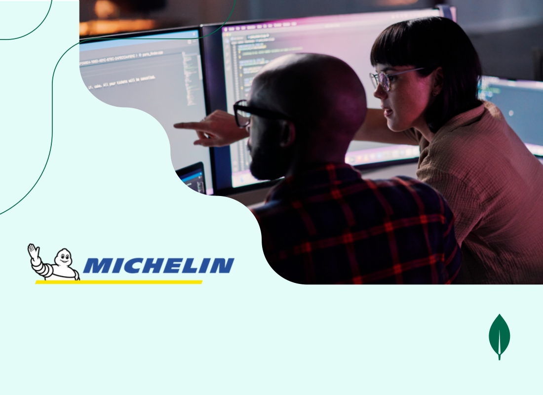 Two professionals happily discussing work while viewing a desktop screen.