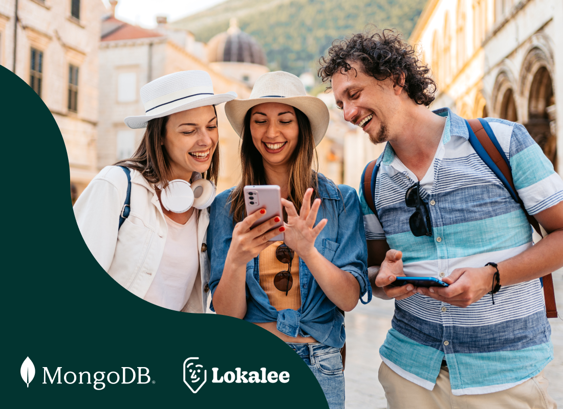 Three people smiling while looking at a cell phone together.