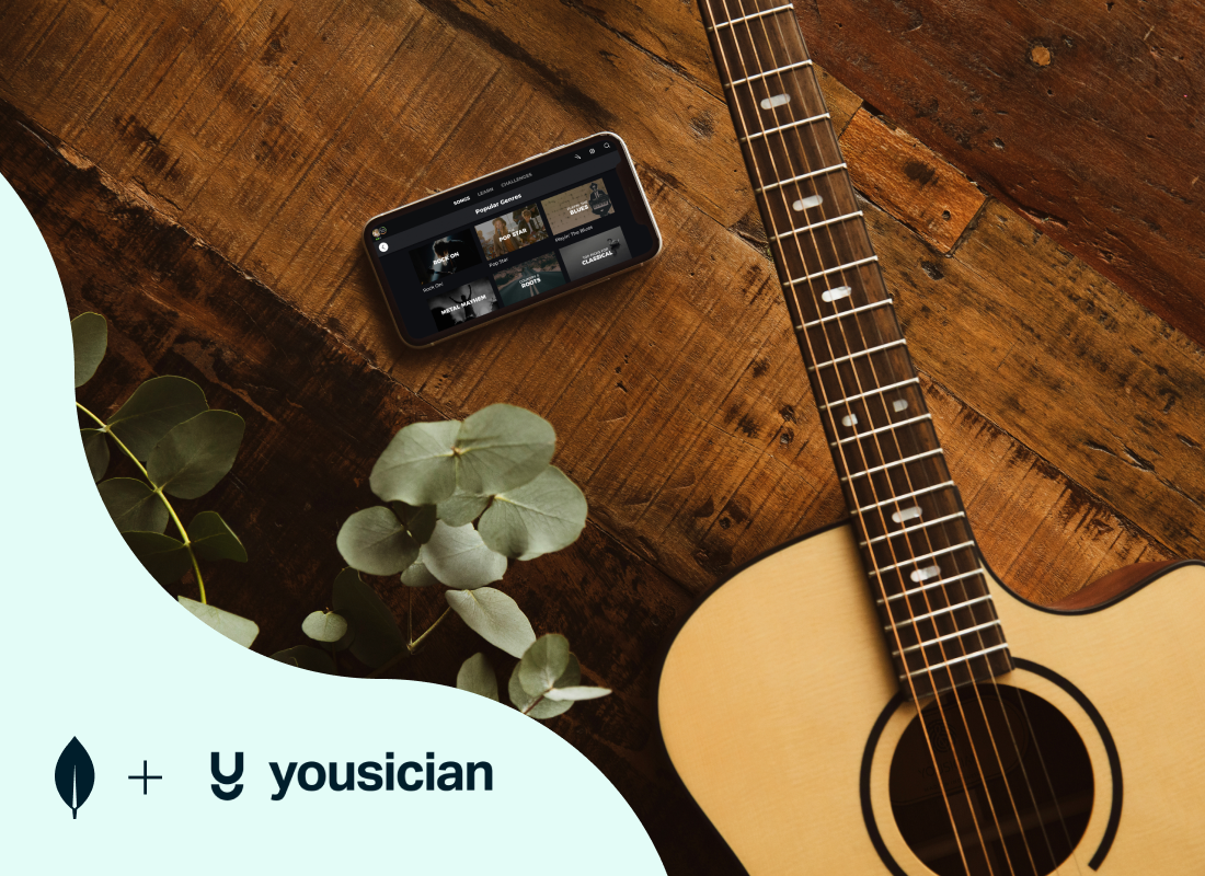 A photo of a guitar and a cell phone lying next to it.