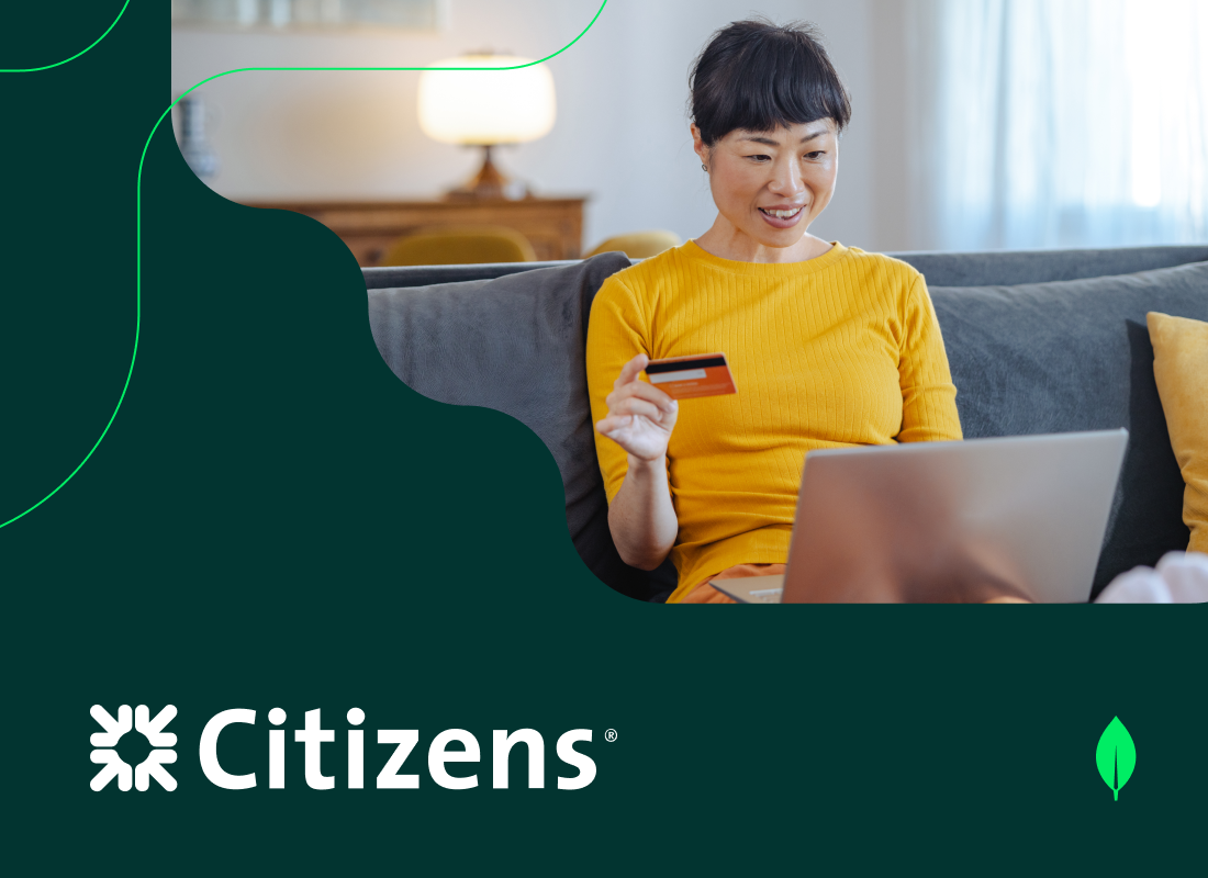 An image of a woman holding a card while working on a laptop, representing a Citizens Bank