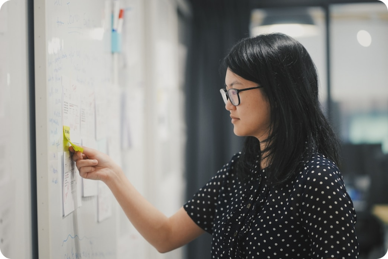 MongoDB employee putting post it notes on a whiteboard