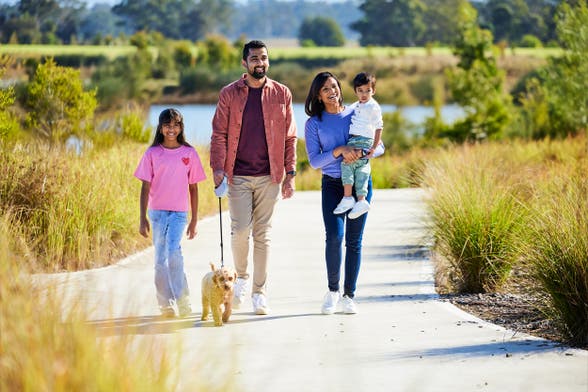 Family walking dog along a nice path in Elara