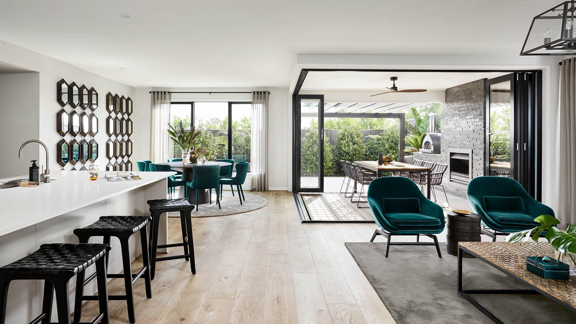 Open plan kitchen, living and dining zone featuring a tropical colour pallette with pops of green.