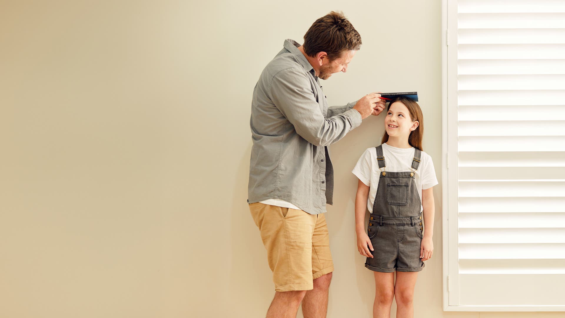 Parent measuring the height of a young child