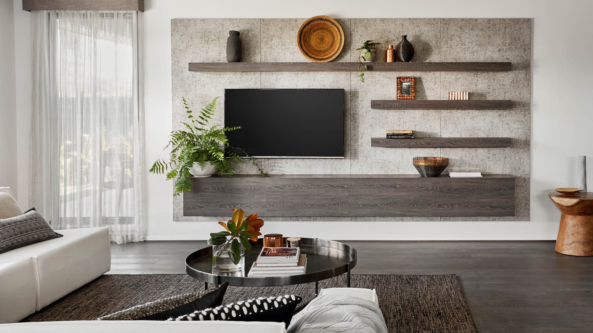 Stylish living area with a wall-mounted TV and greenery accents.