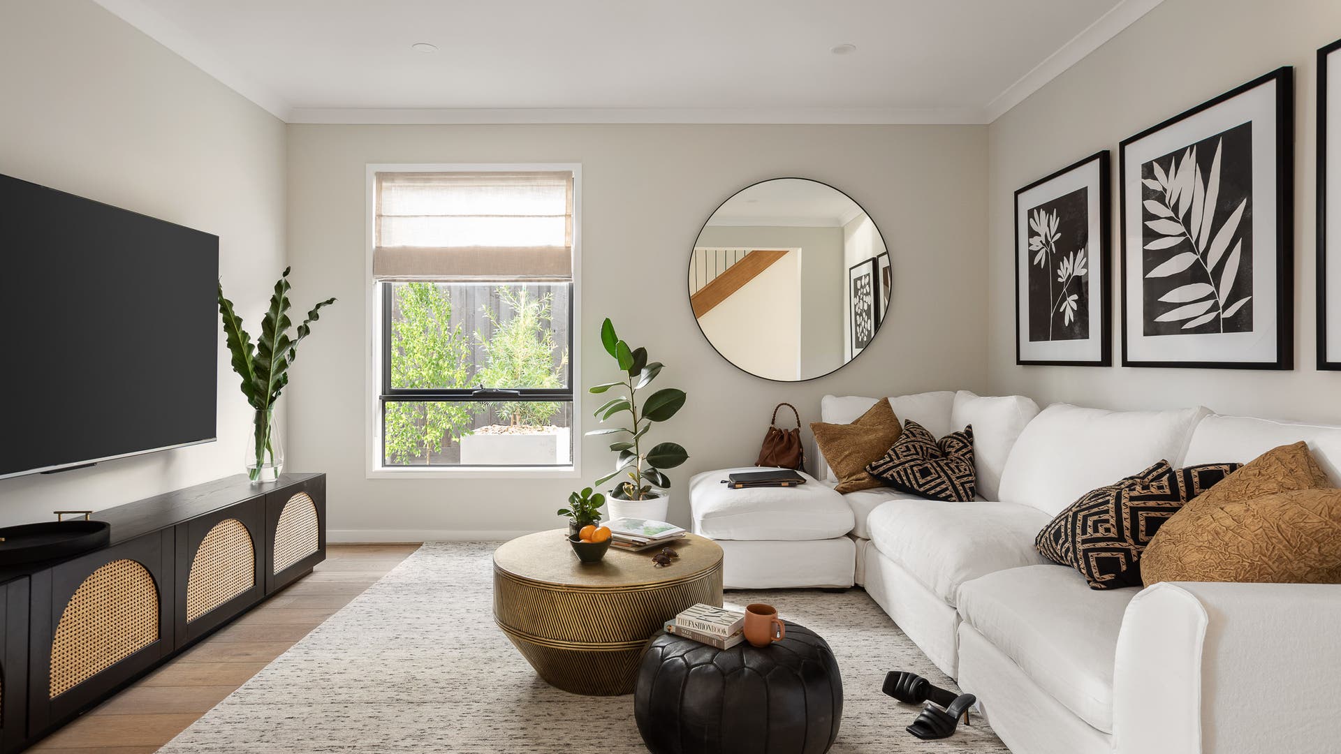 Theatre room featuring white wall paint, light brown flooring and a comfy white couch.