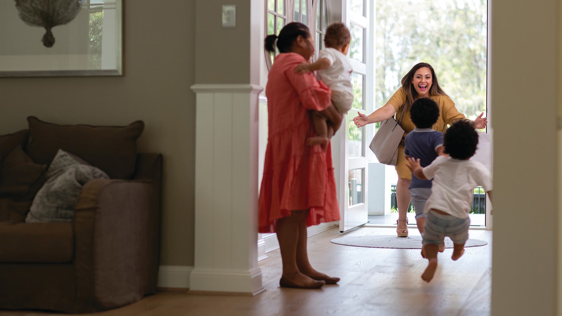 A happy family with children joyfully greeting their loved one at the door, capturing a warm and welcoming moment of reunion.