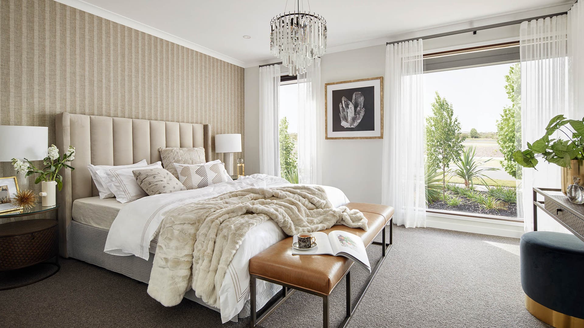 Spacious modern bedroom with natural white and warm yellow coloured walls and furniture and big windows with sheer curtain.