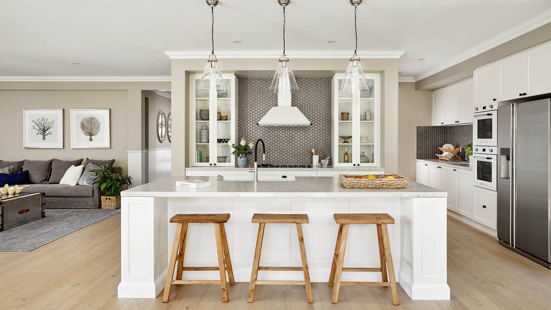 Open, spacious kitchen with natural white tones, tile backsplash, and plantation-style design.