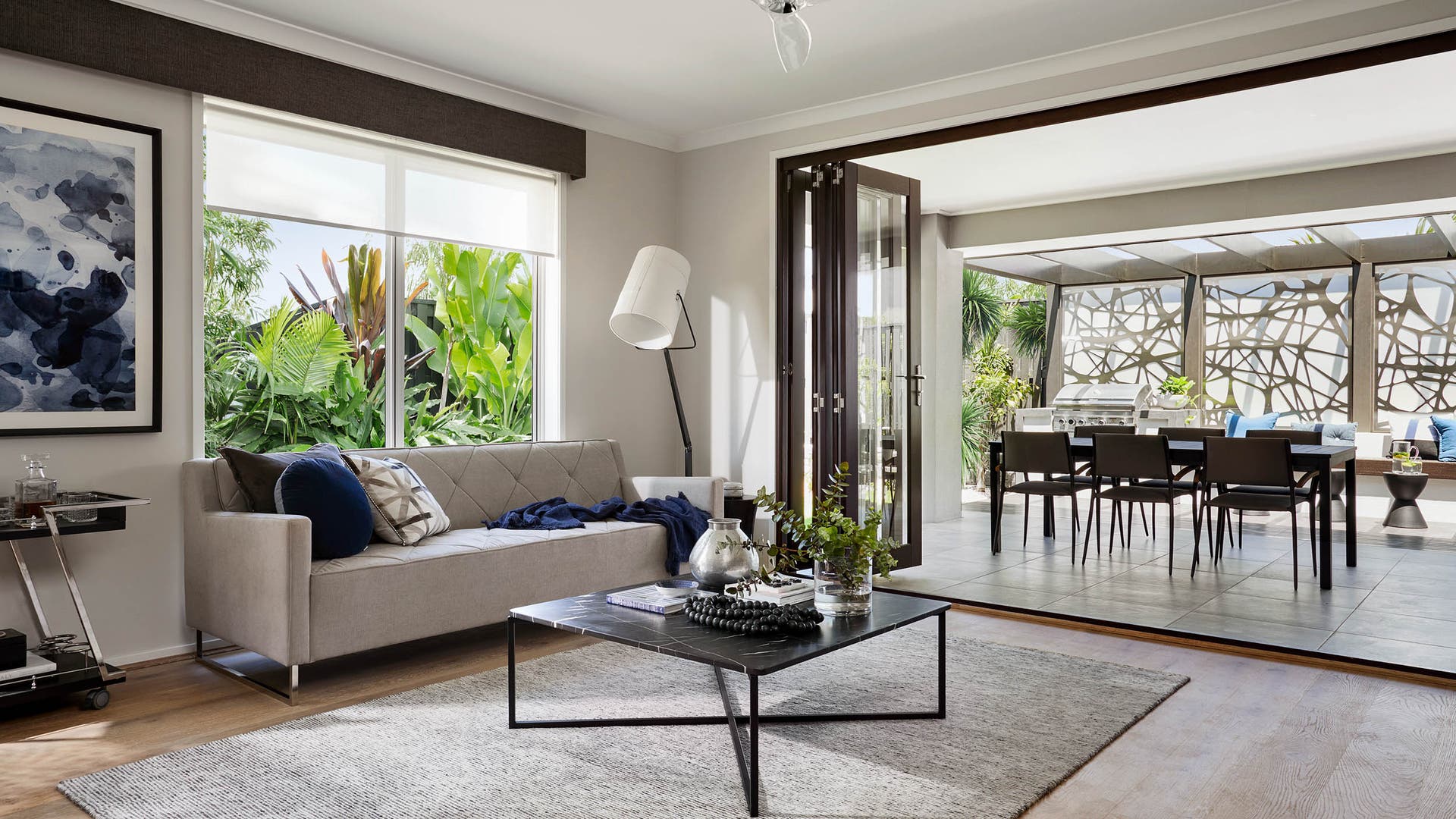 Modern living room connected to an alfresco area, with a fully equipped kitchen and dining area.