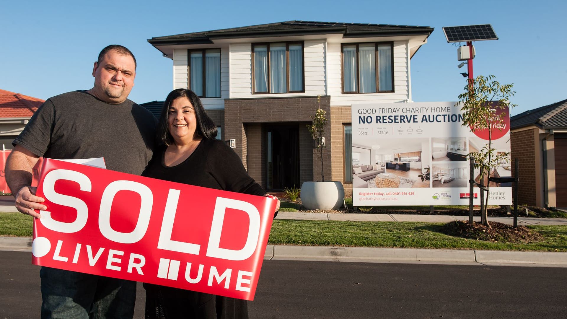 Successful bidders of the 2020 Good Friday Appeal Charity Home standing in front of the double storey home with a red sold sticker.
