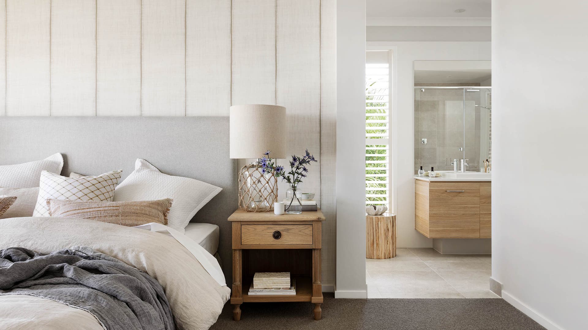 Bedroom and restroom with warm grey and cool neutral-toned walls and interiors.