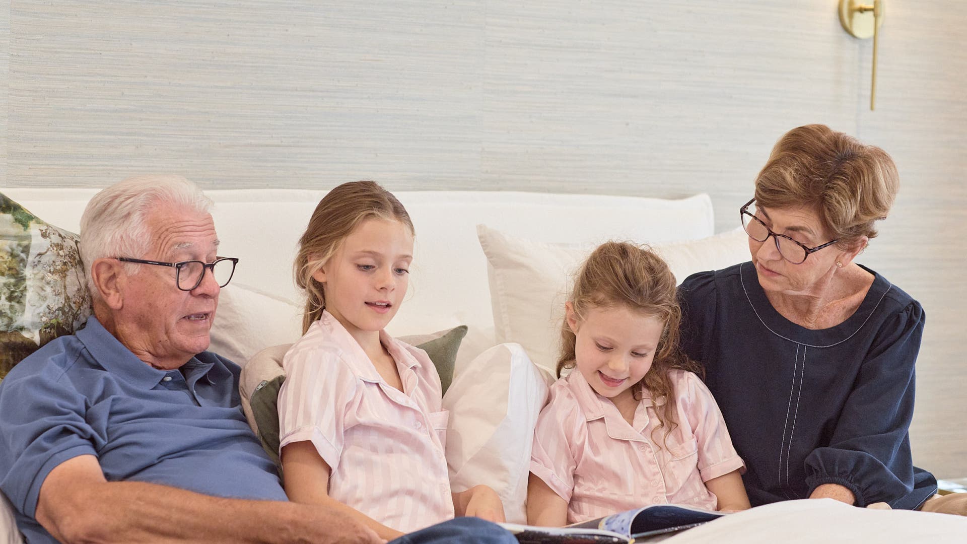 Grandparents & grandchildren reading on a lounge together