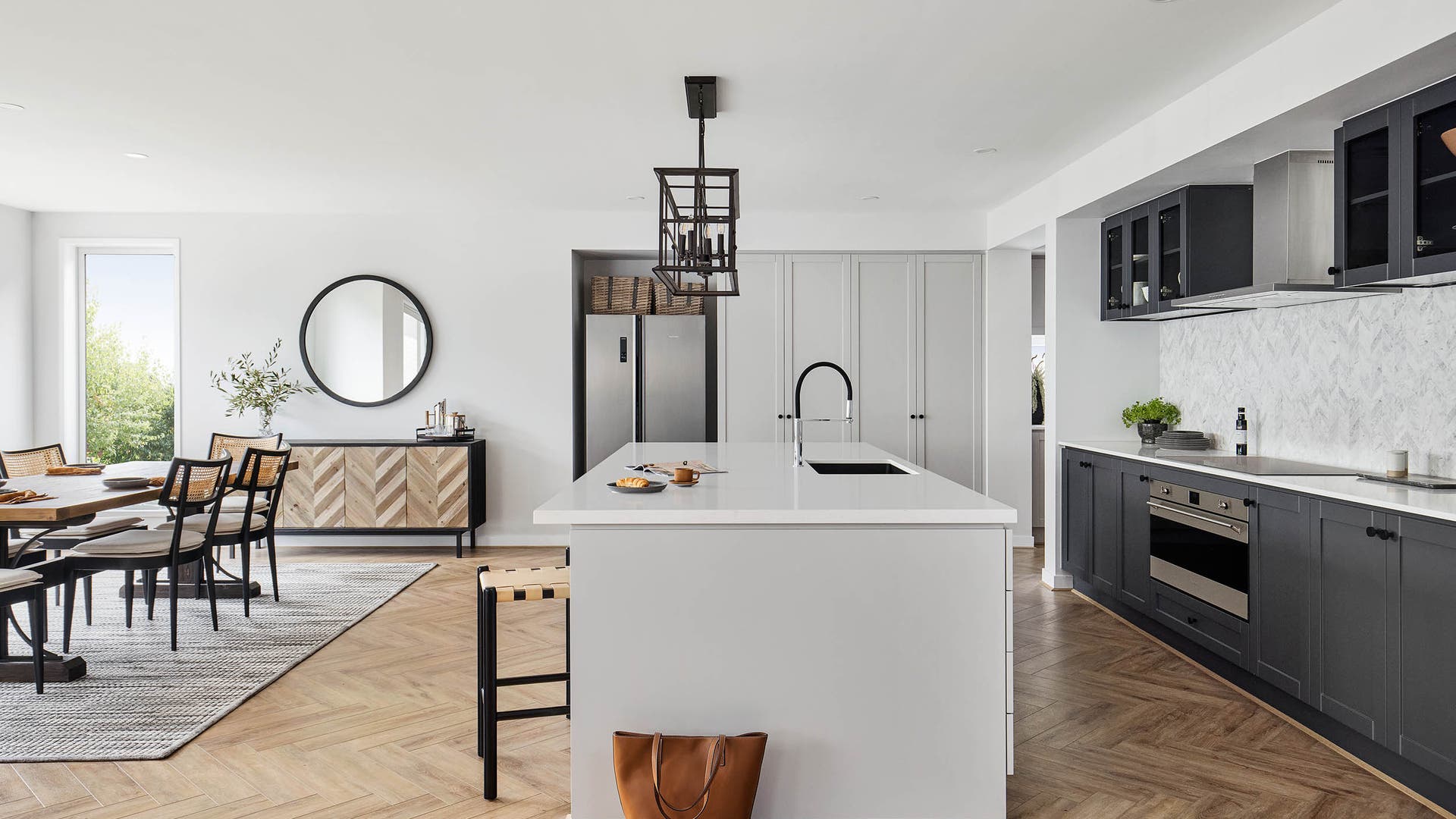 Emperor 41 open plan kitchen and dining layout featuring a contrast of lights and darks, country v panneling and light herringbone timber flooring.