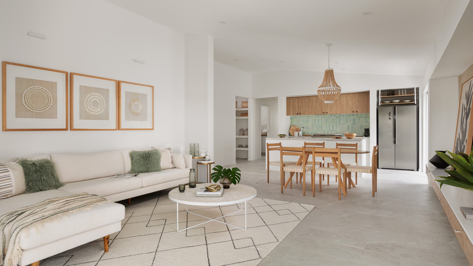 Modern living room and kitchen with a dining area styled in sage green and natural white colours