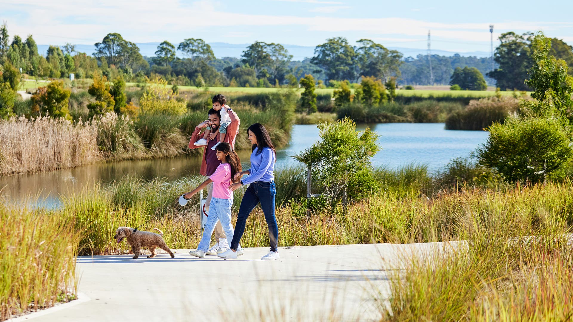 family walking their dog along the waters edge