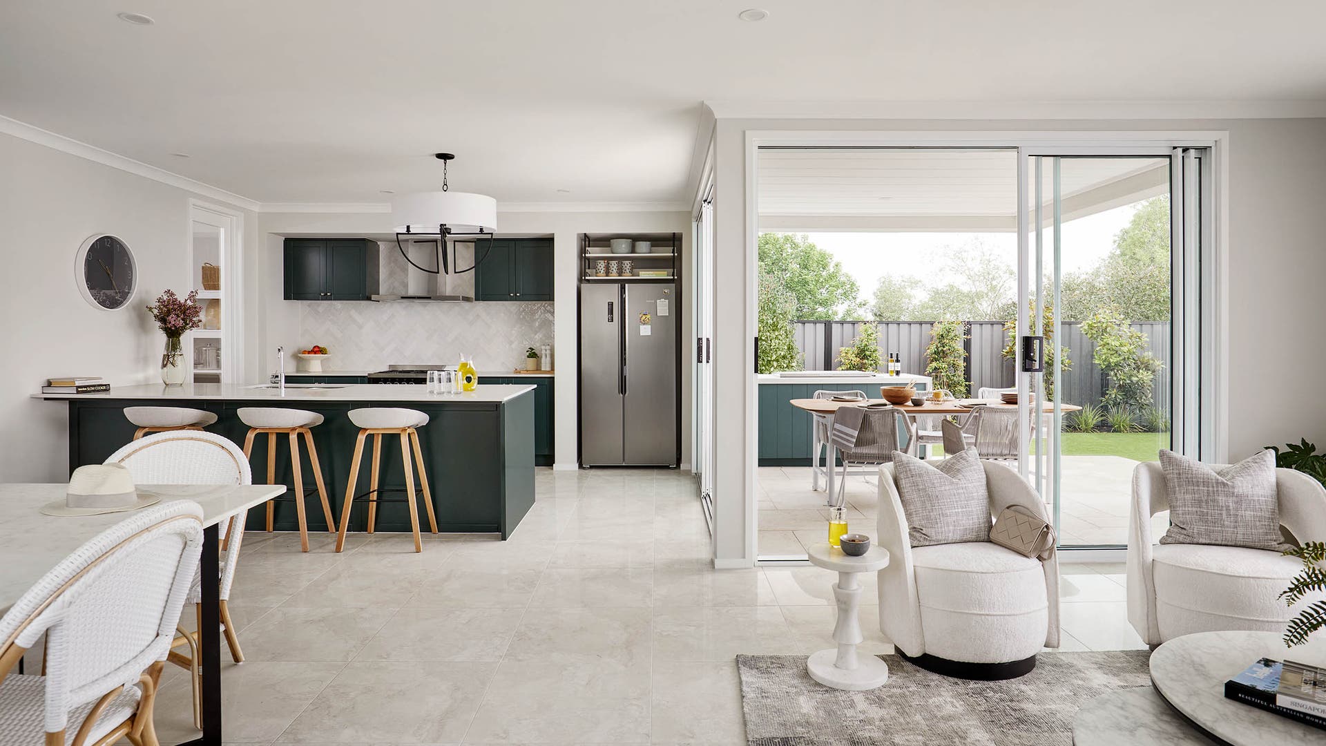 Ashbury 34 - open plan living. Featuring a dark green kitchn with a herringbone splashback and windows and entertaining sliding doors across the dining, family, kitchen and lounge spaces.