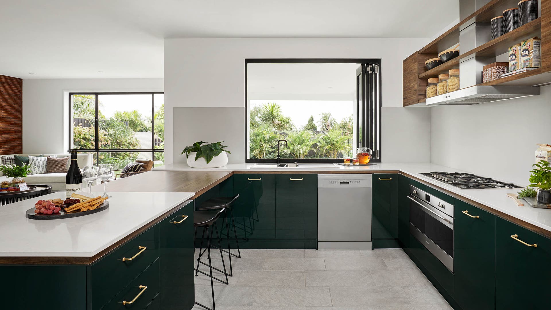 Modern minimalist kitchen with green cabinetry styled with luxurious gold accents.