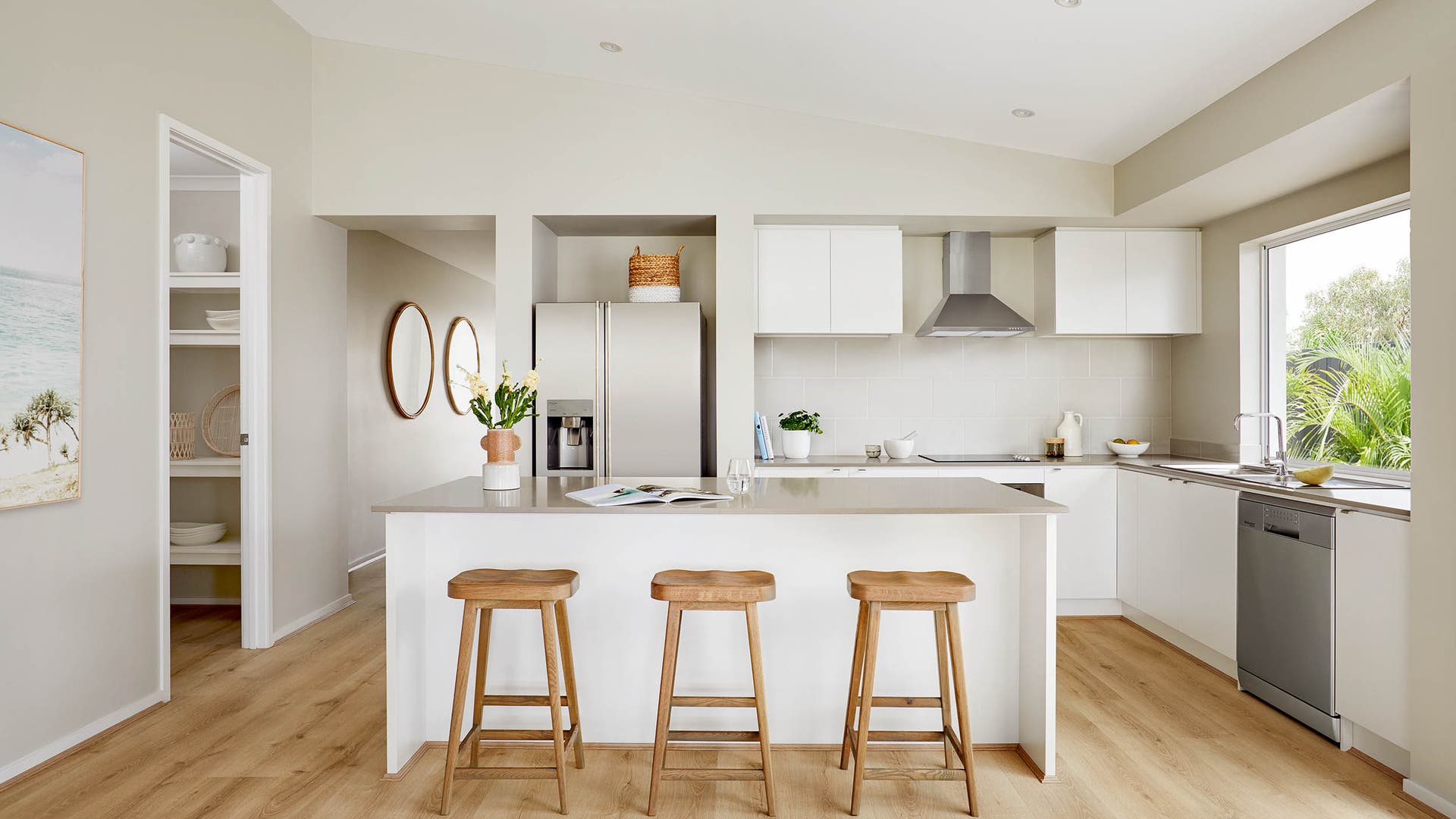 Open kitchen area featuring a neutral-style interior with sleek countertops, modern appliances, and a spacious butler's pantry for additional storage