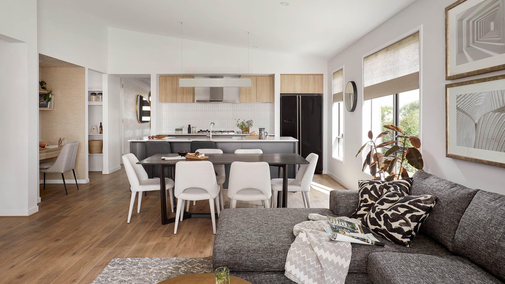 Cohen 22 Kitchen and dining on display in Cranbourne featuring an open plan kitchen with white kitkat splashback and a raked ceiling.