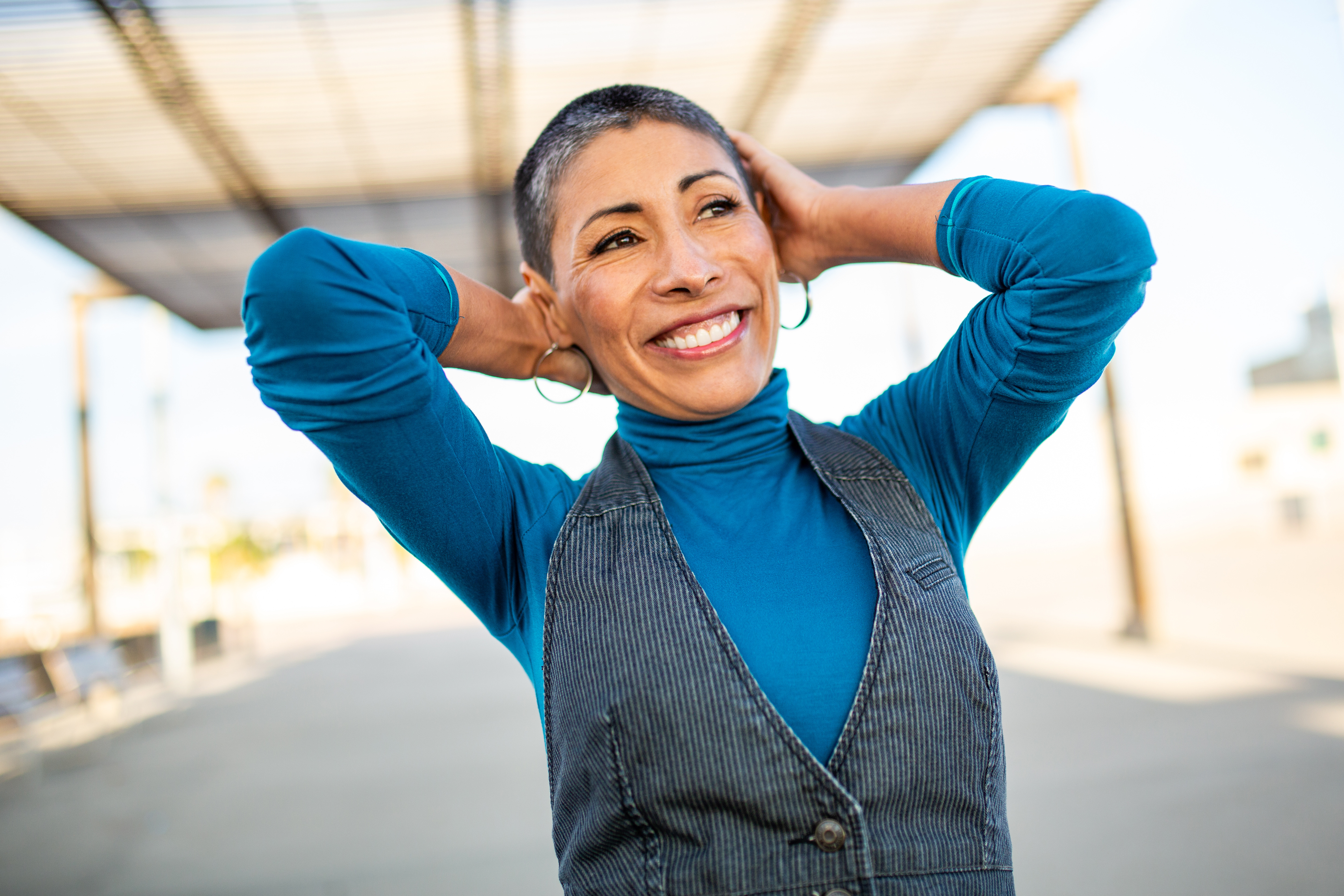 Smiling woman in a blue turtleneck and gray vest