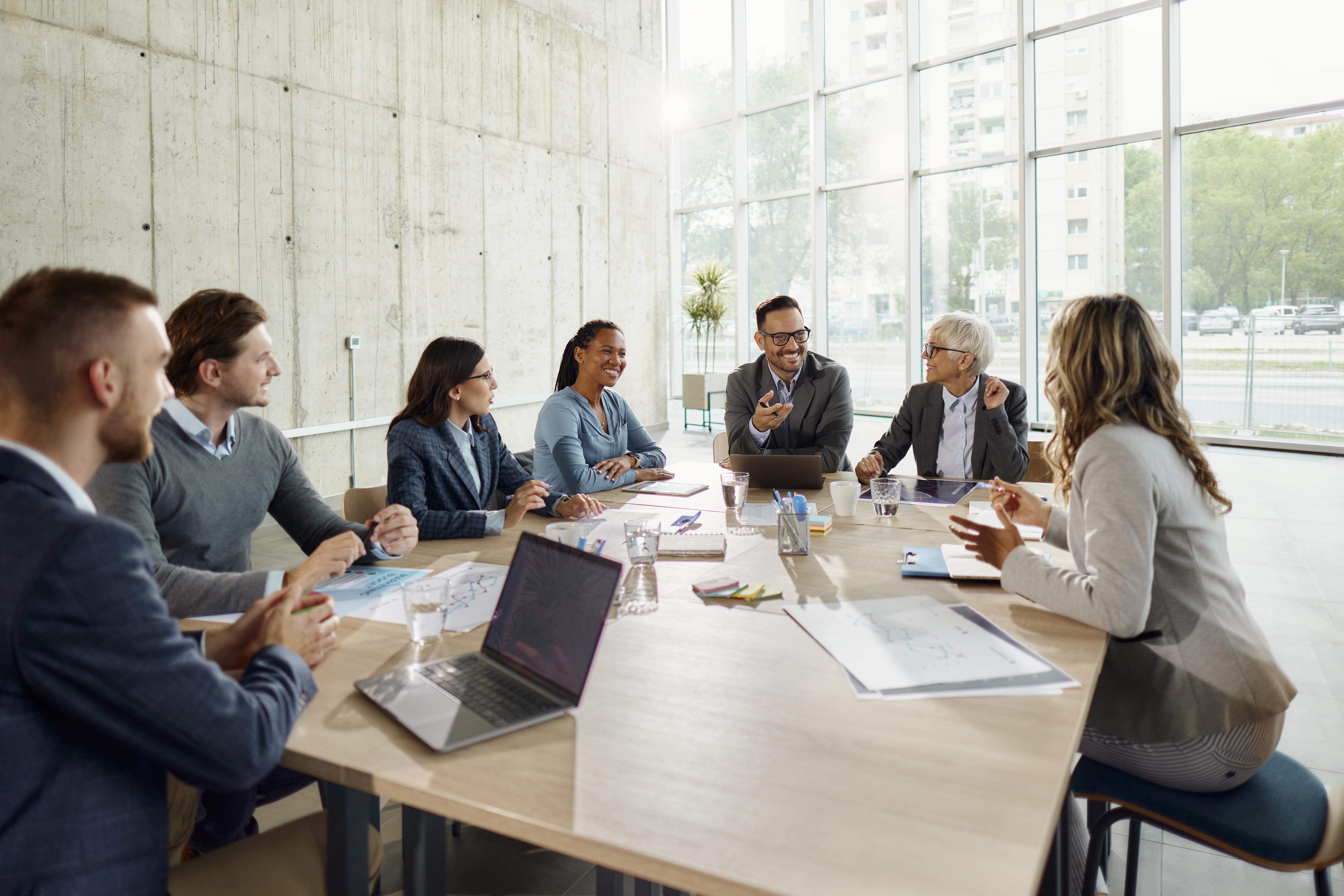 Large group of happy business colleagues communicating while working on a meeting in the office. 