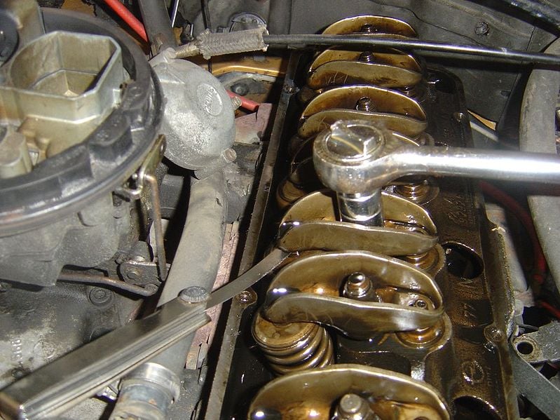 A valve lash adjustment being performed