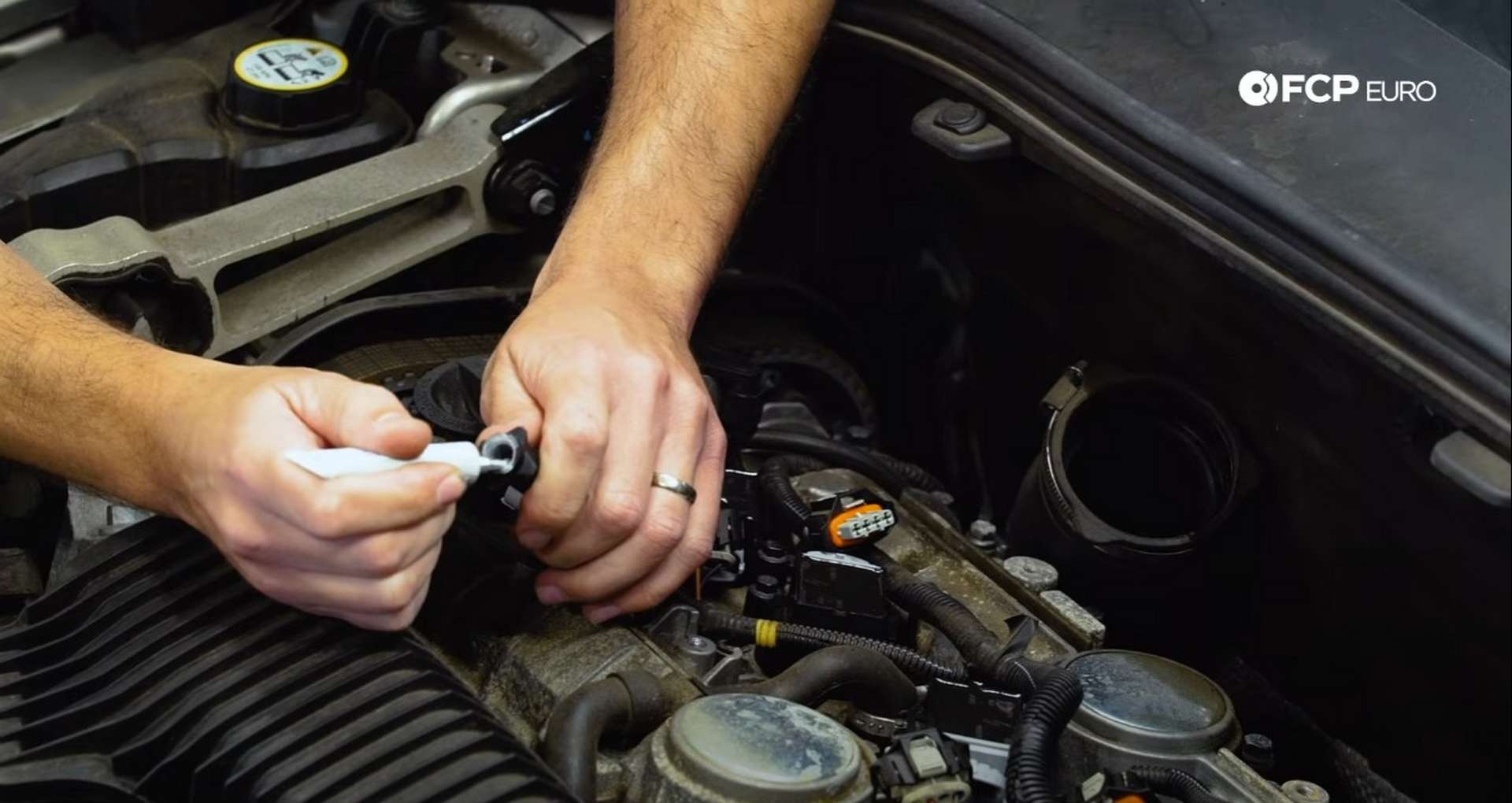 DIY Volvo Spark Plug and Ignition Coil Replacement placing the dielectric grease onto the ignition coil