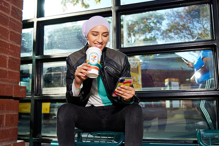 Woman taking a break drinking a coffee with her phone