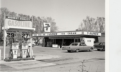 Two gas pumps outside a 7-Eleven in the 1960s