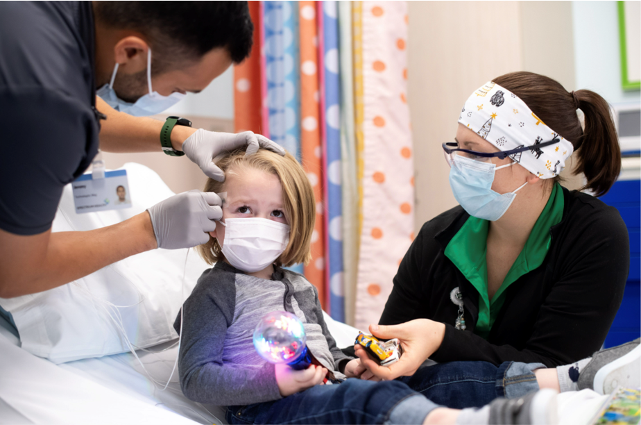 nurse placing sensor on little girl's forehead