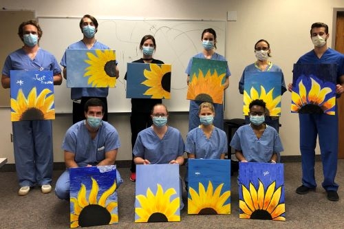 Plastic Surgery residents showing off their sunflower paintings