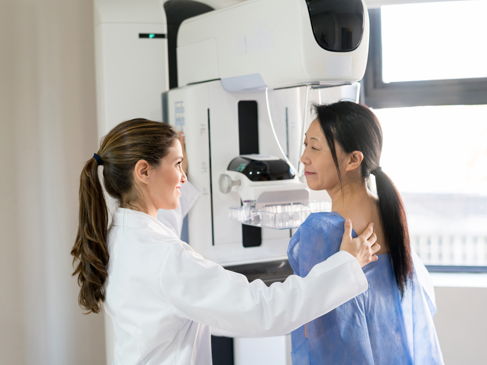 Technician running a mammogram on a patient