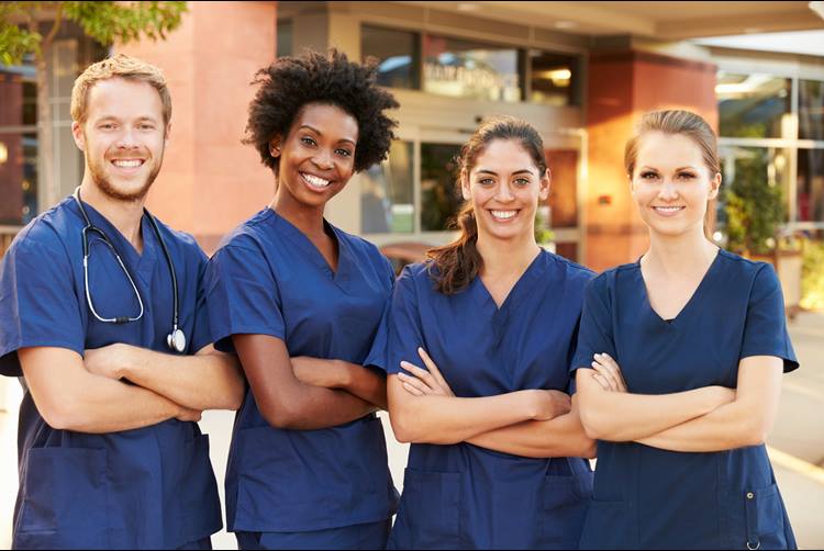 Four nurses, smiling for photograph.
